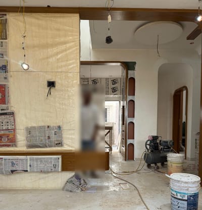 Living room under construction with marble-finish TV wall and arched doorways